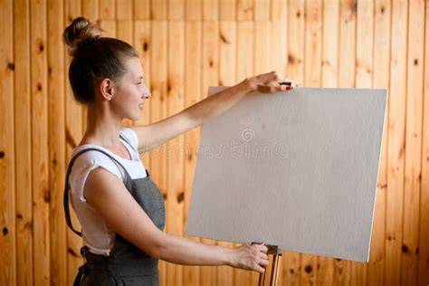 Man Artist Stands In Front Of A Blank Canvas On Easel With Palette In