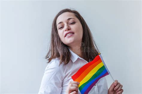 beautiful caucasian lesbian girl with lgbt rainbow flag isolated on white background looking
