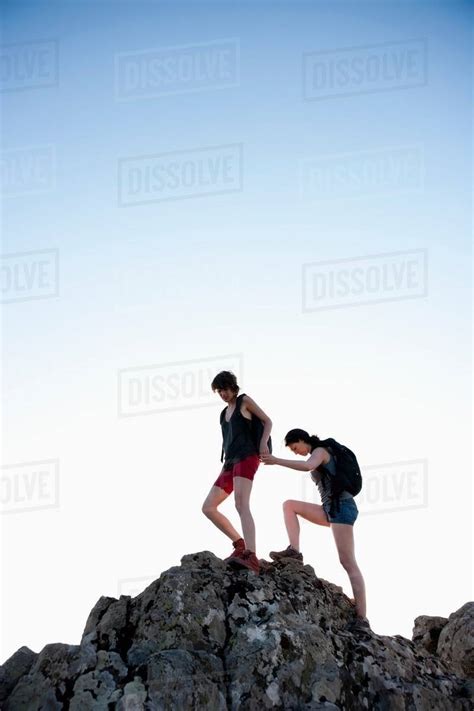 Hikers Helping Each Other Climb Rock Stock Photo Dissolve