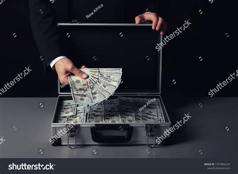 Businessman With Suitcase Full Of Money On Dark Backgroundfullsuitcase