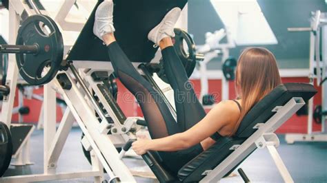 A Sportive Woman Exercising In The Gym Performing A Leg Press On The