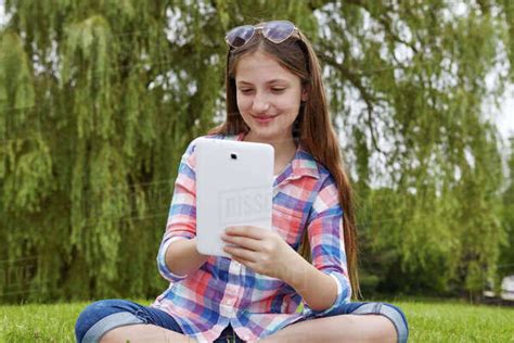Preteen Girl Sitting In A Park Holding A Tablet Toronto Ontario