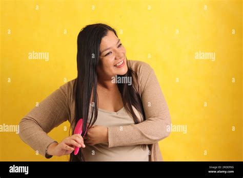 40 Year Old Latina Woman Brushes Her Straight Hair With Difficulty
