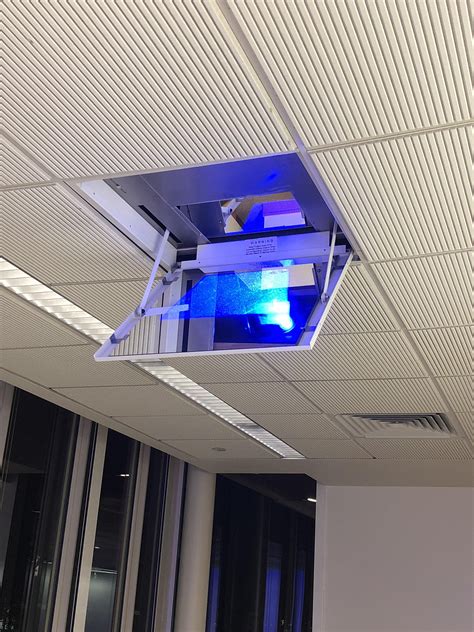 In every ceiling, there are frames that support its structure, called levitating projector screens have their bracket connectors at the back. A room at my school uses a vertical hidden projector and a ...