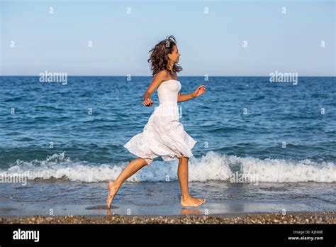 Woman Running Along The Beach Stock Photo Alamy