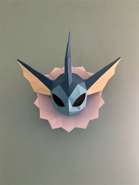 An Origami Mask With Horns And Eyes On Top Of A Paper Piece That Looks
