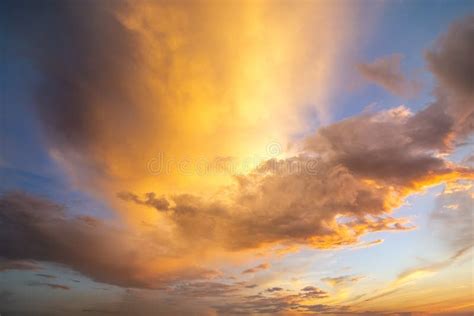 Dramatic Yellow Sunset Landscape With Puffy Clouds Lit By Orange