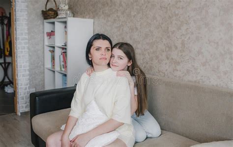 Retrato De Una Joven Madre Y Su Hija Abrazándose En Casa En El Sofá