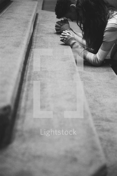 A Man And Woman Kneeling In Prayer — Photo — Lightstock