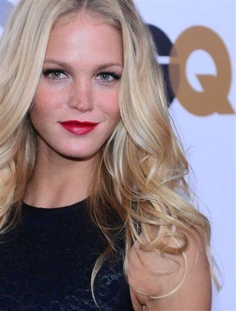 A Woman With Long Blonde Hair Wearing A Black Dress And Red Lipstick On