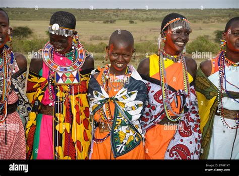masai women wearing colorful traditional dress singing laughing and smiling in a village near