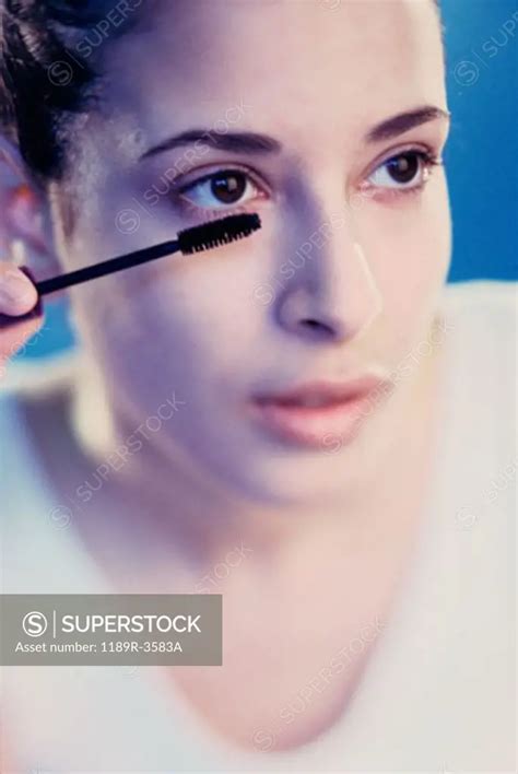 Close Up Of A Young Woman Applying Mascara Superstock