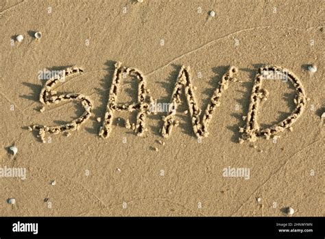 Word Sand Written By In The Sand Can Be Used As Background Stock Photo