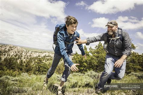 Father And Teenage Son Chasing Each Other On Hiking Trip Cody Wyoming