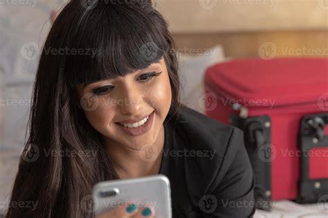 Pretty Young Woman With Suitcase In Modern Hotel Apartment Using Phone