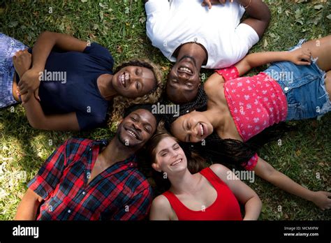 Group Of Friends Lying On The Grass Laughing Stock Photo Alamy