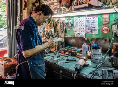 A local gunsmith, is fixing a part of a firearm, in his workshop, at
