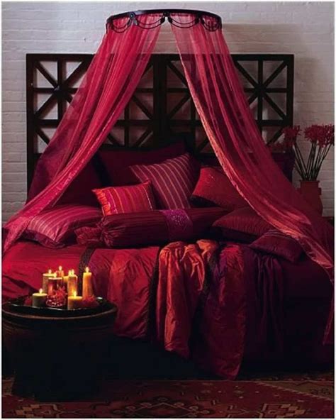 Romantic Bedroom With Deep Red Bedding And Canopy Fabrics With Candles