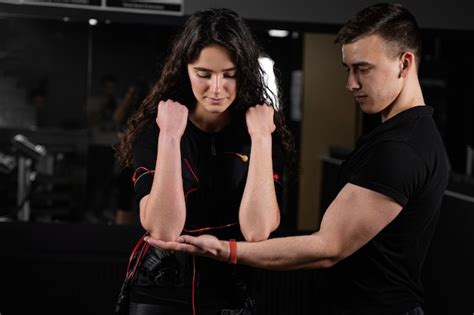Premium Photo Man Trainer Trains A Girl In An Ems Suit In The Gym