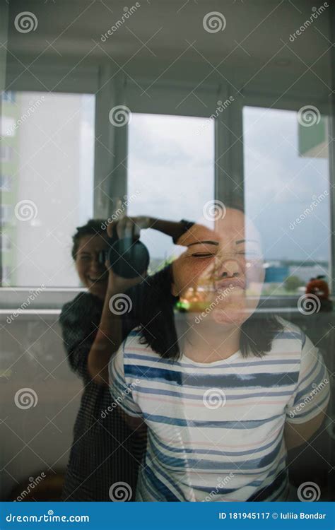 Young Girl Taking Picture Of Her Mother Through The Window Funny Face