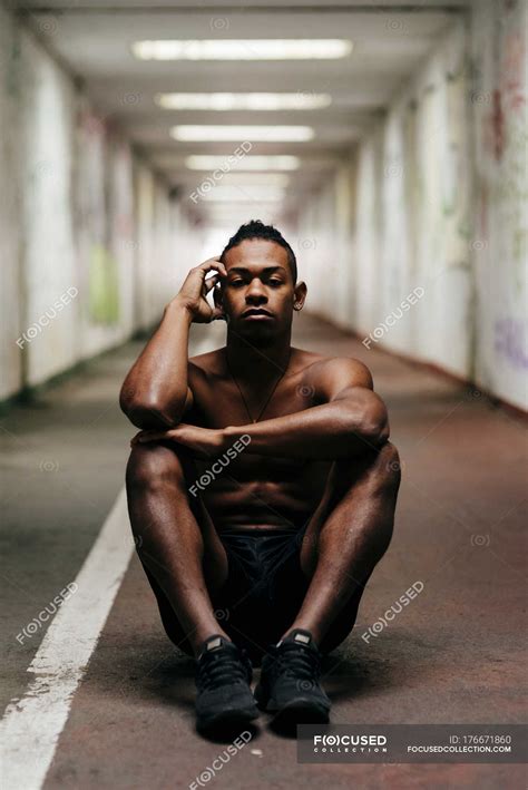 Shirtless Sportsman Sitting On Floor At Underground Passage Lifestyle