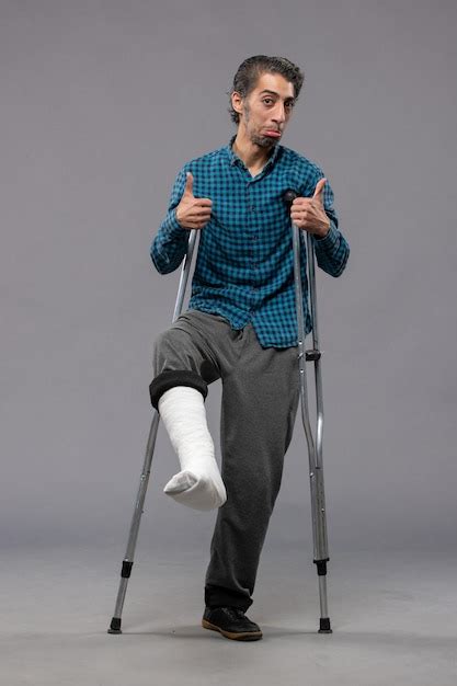 Free Photo Front View Young Man Using Crutches Due To Broken Foot On