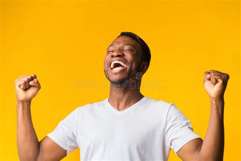 Happy Black Man Screaming And Shaking Fists Over Yellow Background