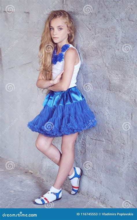 Beautiful Little Girl Model Posing While Leaning Against A Wall In A