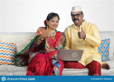 Happy Indian Senior Couple Having A Video Call On The Laptop And Showing Thumbs Up At Home Stock