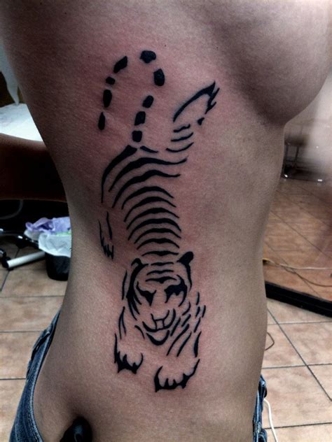 A Black And White Tiger Tattoo On The Side Of A Womans Lower Back