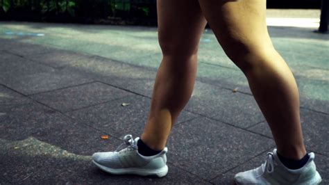 Fit Young Woman Walking Powerfully Down The Sidewalk In The City Stock