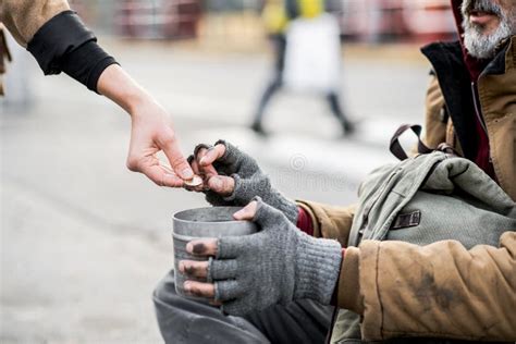 A Midsection Of Woman Giving Money To Homeless Beggar Man Sitting In City Stock Image Image
