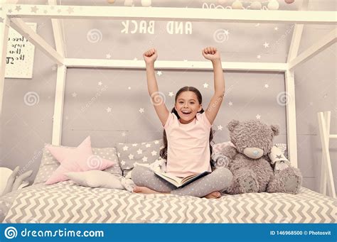 Enjoy Concept. Happy Girl Enjoy Staying In Bed. Little Child With Raised Hands Enjoy Reading 