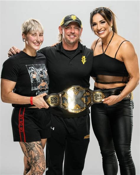 rhea ripley and raquel gonzález share a picture with their beloved pc coach scotty 2 hotty as