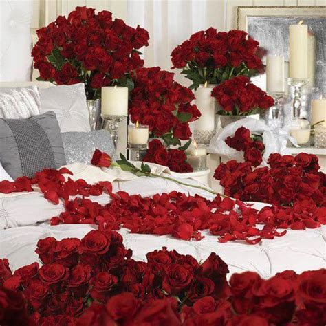 Rose petals on bed with candles. Room Full with Red Roses