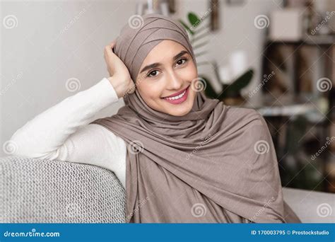 beautiful arabic woman in hijab sitting on couch posing to camera stock image image of happy