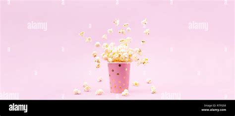 Flying Popcorn In A Bright Glass And On A Pink Background Copy Space