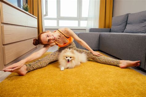 Redhaired Ginger Woman In A Stylish Top And Leggings Doing Yoga Asana