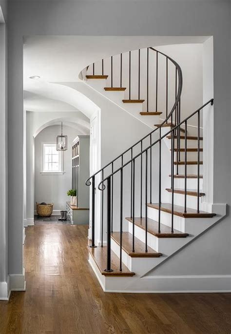Curved Staircase With Wrought Iron Handrails And Spindles Featuring