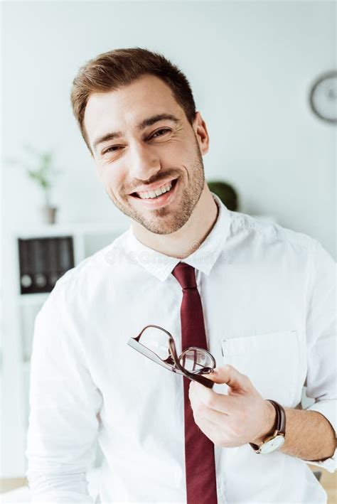 Cheerful Handsome Businessman Holding Eyeglasses And Looking Stock Image Image Of Executive