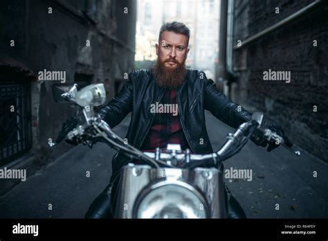 Bearded Biker In Leather Jacket Sitting On Classical Chopper Front