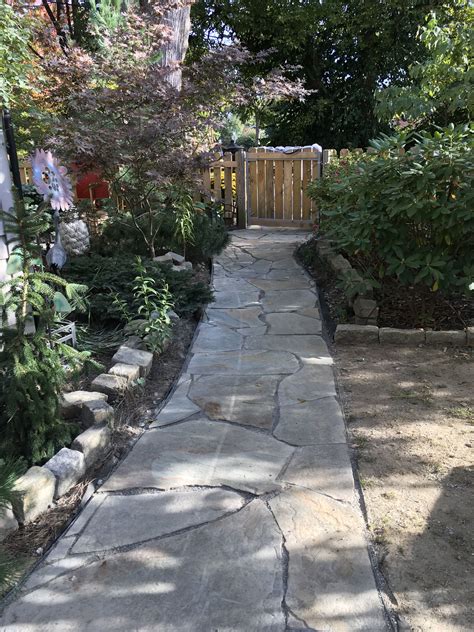 A stone walkway has rustic charm that is ideal for a cottage garden design but is equally suitable for any natural landscape plan. dIY Pennsylvania Blue stone | Stone walkway, Blue stone ...