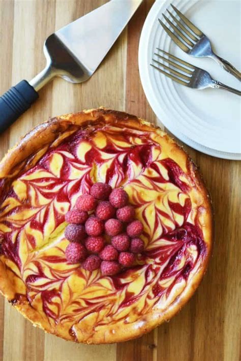 Oreo cookie crust with a raspberry cheesecake filling, topped with raspberry sauce and whipped cream. White Chocolate Raspberry Cheesecake Recipe | A Wicked Whisk