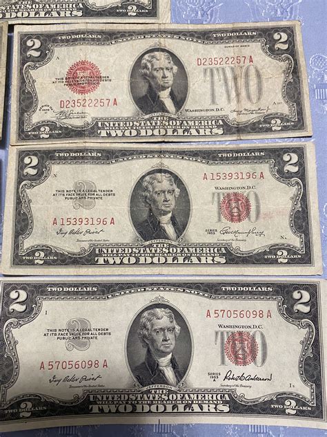 Seven red two dollar bills four bills are from 1953 and the other three
