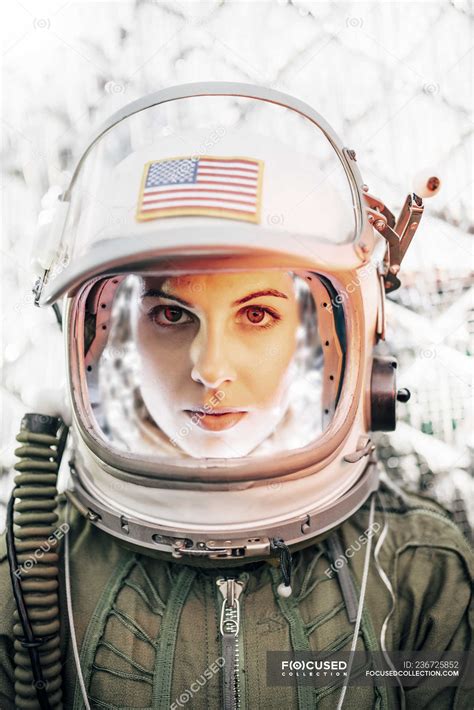 confident girl wearing old space helmet with american flag sign on foil background — work