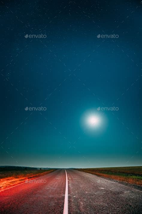 Night Starry Sky With Moon Above Country Asphalt Road In Country Stock