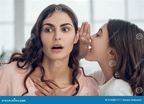 daughter telling secret to mother in whisper in ear stock image image of home happiness