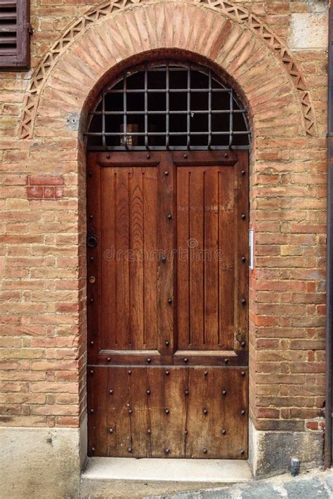 Wooden Arch Door On Medieval Brick Building In Siena Italy Stock Photo