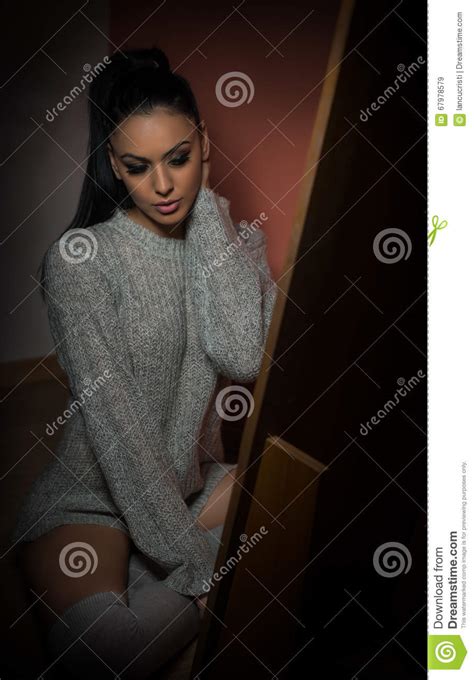 Atrakcyjna Seksowna Brunetka W Białym Wygodnym Pulowerze Pozuje Indoors