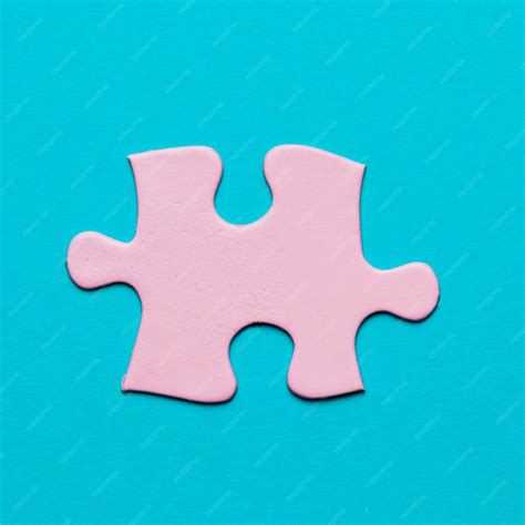 青色の背景にピンクのジグソーパズルのピースのクローズアップ 無料の写真